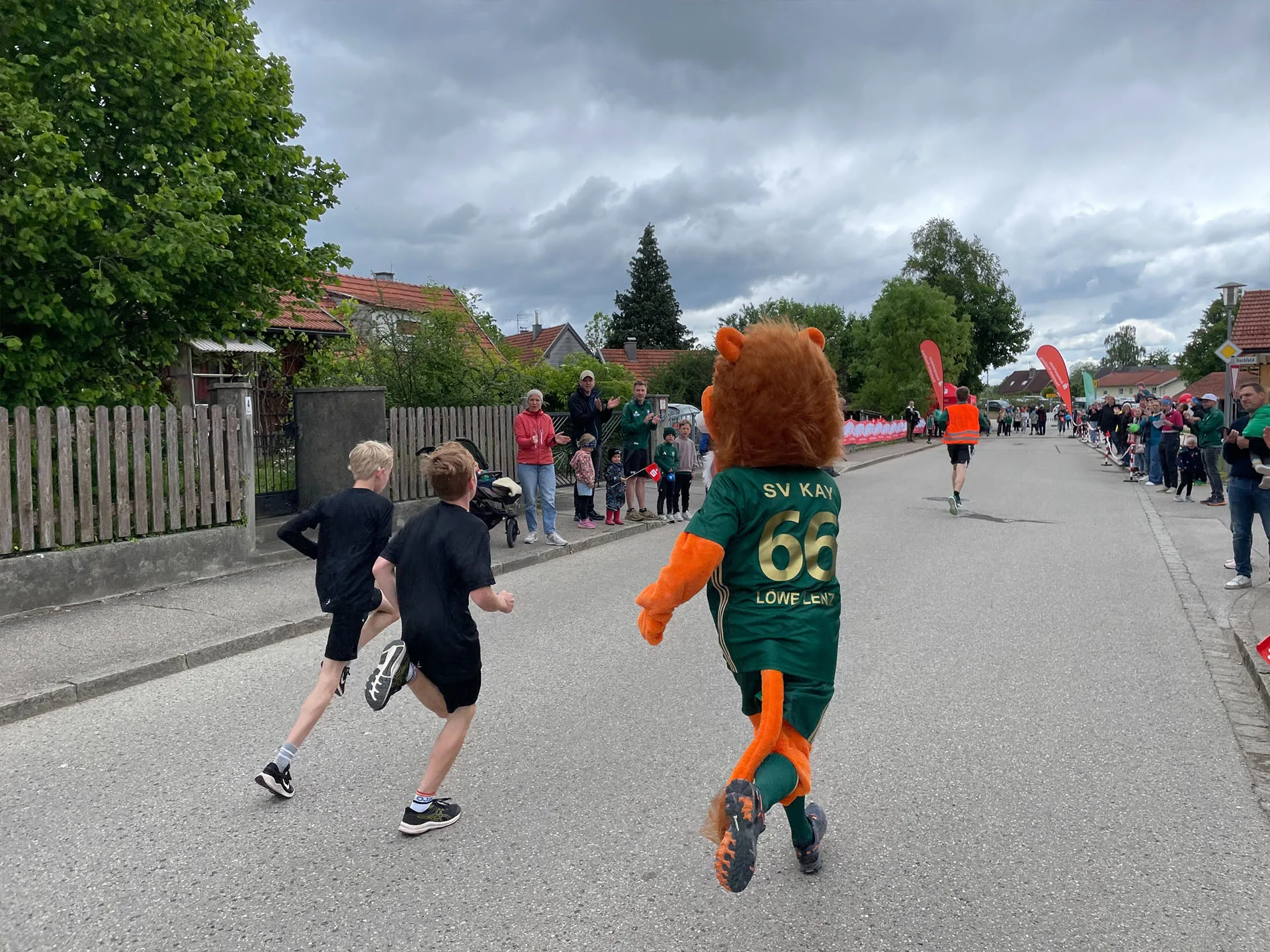 Jungs während dem Kayer Löwenlauf mit Löwe Lenz am Zielbereich